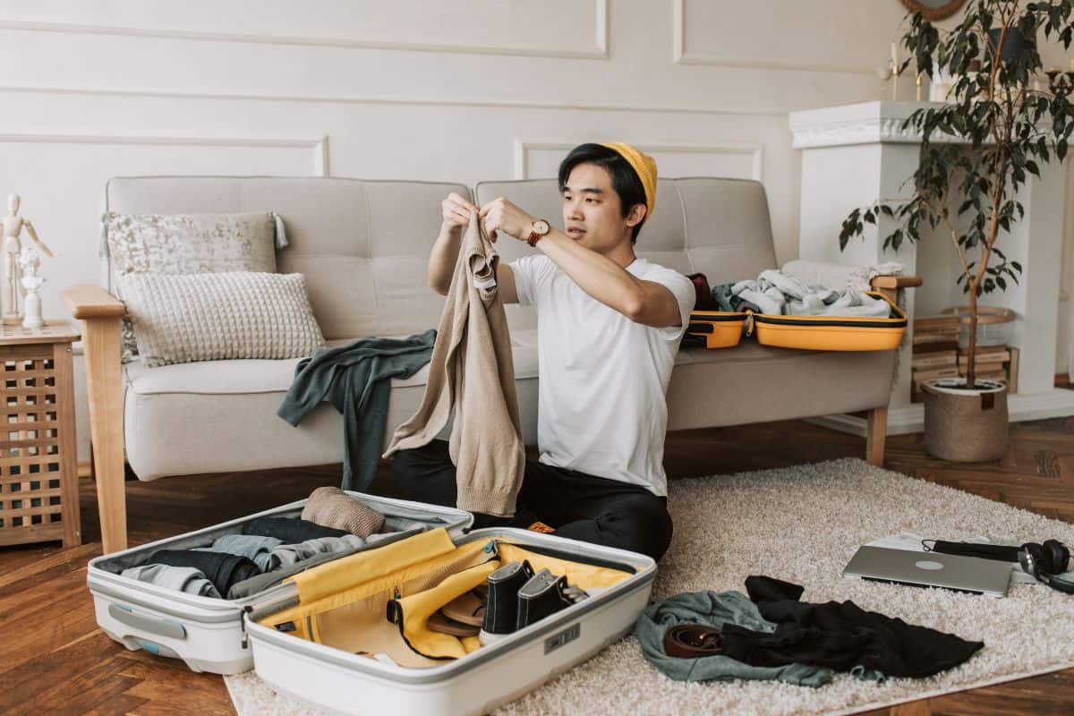 person packing suitcase disposable vape, traveler holding high puff vape Australia, vape for weekend trip - What Happens If You Put a Vape in Checked Luggage?