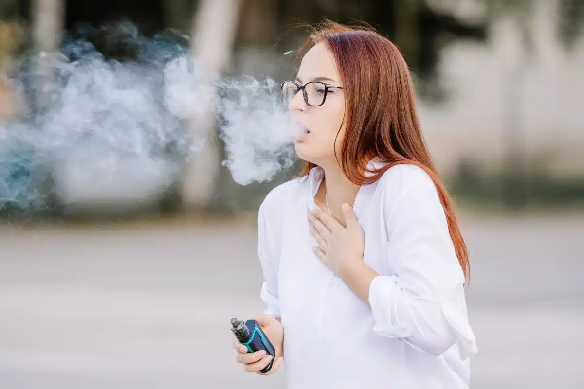 person transitioning from smoking to vaping, ex-smoker holding vape, throat hit craving - How to Avoid Vape Burning Your Throat - Red Vape