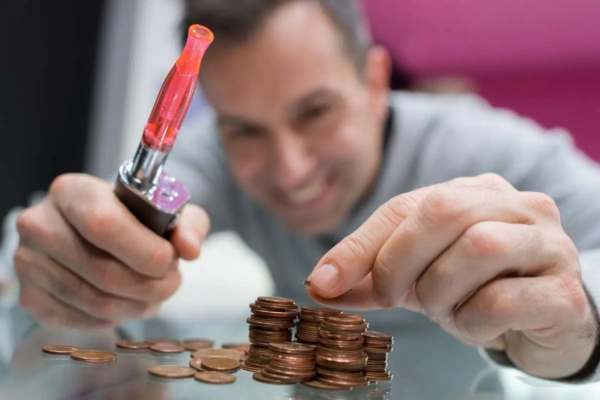 money saving vape, cost effective vaping device, stack of coins with vape - Vaping on a Budget – Our Top Tips - Red Vape